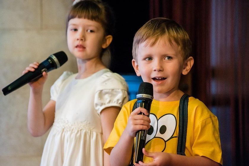 Дети выступают с микрофонами на отчётном концерте студии Vocal Premium
